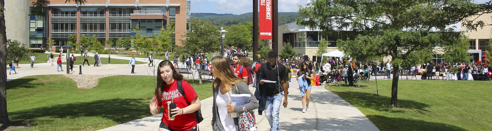 large group of students walking in quad near clocktower